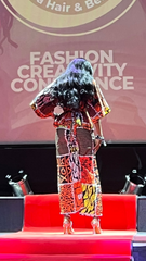 Model on a catwalk with 'Afro bella Hair & Beauty Bar' logo in background